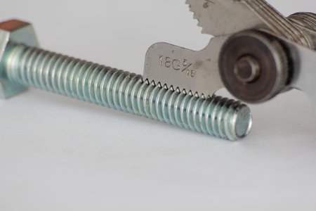 Close up of Thread gauge  and nuts on white background. Selective focus.