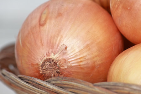 onion in a wicker basket on a light background close-upの写真素材