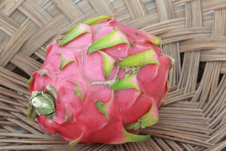 Dragon fruit in a basket on the table, closeup of photoの写真素材