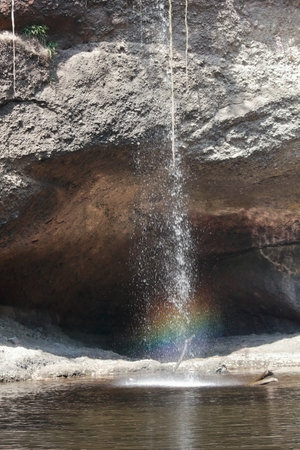 Waterfall in the forest with rainbow in the middle of the waterの写真素材