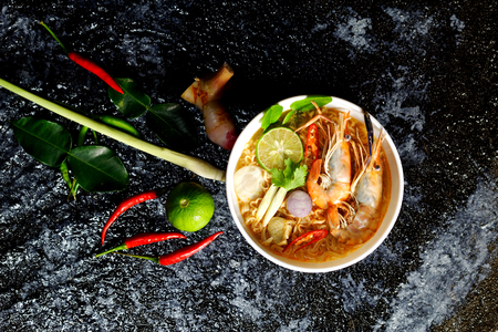 Spicy instant noodles soup with shrimp (tom yum kung) on dark backgroundの写真素材