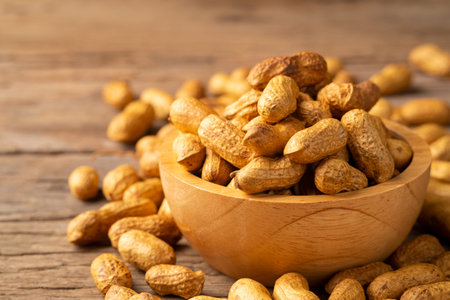 Sand roasted nuts in wooden bowl on wood plate background