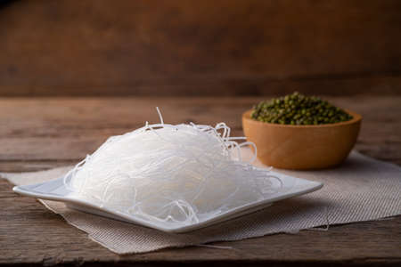 Fresh Glass Noodle (Transparent bean vermicelli) on white plate with Green beans on spoonの写真素材