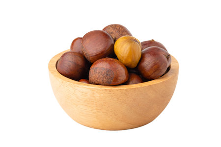 Roasted chestnuts in wooden bowl isolated on white backgroundの写真素材