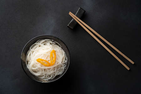 Rice vermicelli noodle in a bowl on dark backgroundの写真素材