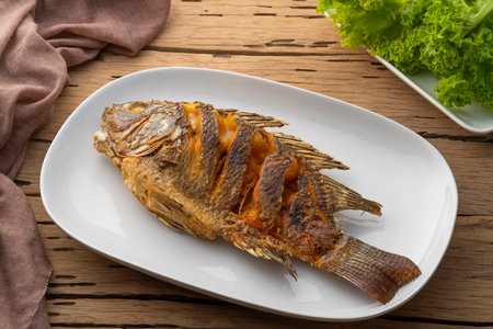 Deep fried Tilapia fish in white plateの写真素材