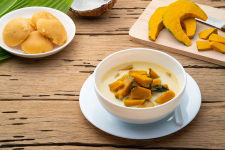Coconut Milk Stewed Pumpkin,Thai dessert boiled sliced Pumpkin fruit in coconut milk with palm sugar in white bowlの写真素材
