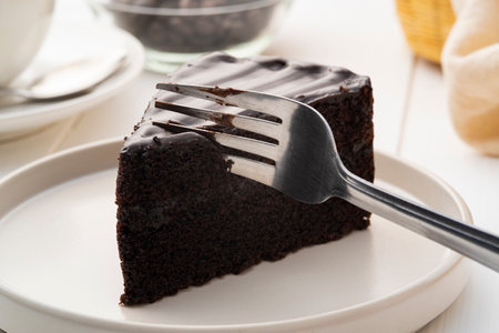 Delicious Sliced of Classic Chocolate Cake with fork on white plateの写真素材
