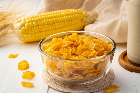 Healthy crispy cornflakes in glass bowl on wood tableの写真素材