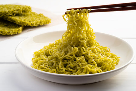 Close up use chopsticks clamp noodles,Boiled green noodles,Cooked dry instant vegetable noodle,Jade...