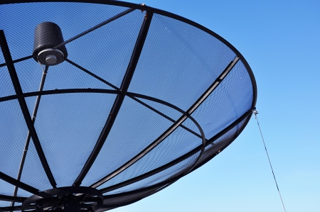 A satellite dish on blue sky backgroundの写真素材