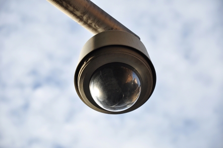 Round shape CCTV on cloudy sky backgroundの写真素材