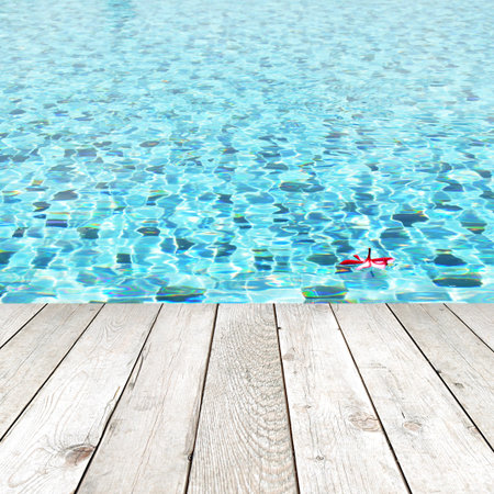 Wood plank on swimming pool water background - spa concept