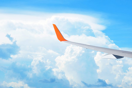 Airplane wing on beautiful blue sky background - tourism & transportation concept