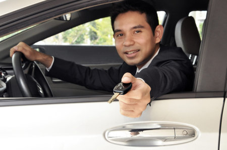 Businessman driver giving a car key