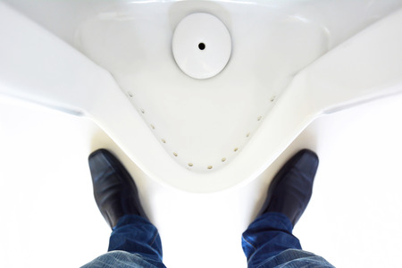 Top view of a man legs in front of urinal in men toiletの写真素材