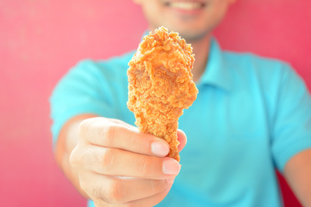 A man giving fried chicken leg or drumstickの写真素材