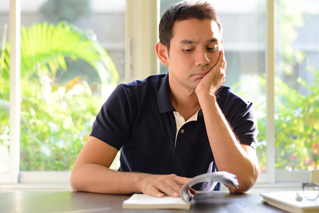 A man reading book - bored & moody conceptの写真素材