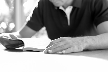A man reading book on the table - monochrome effectの写真素材