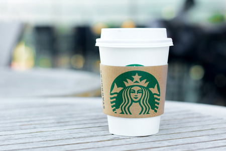 Starbucks take away coffee cup with logo on sleeve, Starbucks brand is one of the most world famous coffeehouse chains from USA.のeditorial素材