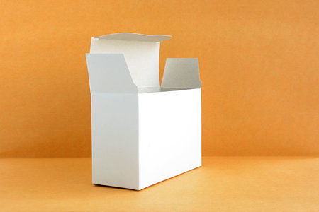 Open white cardboard box on light brown background - soft focus