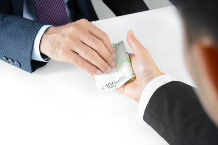 Businessman hands giving & receiving money, Euro currency (EUR) - bribery conceptの写真素材