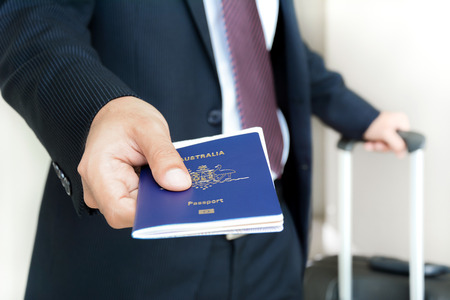 Businessman giving passport with boarding  pass inside - soft focusの写真素材