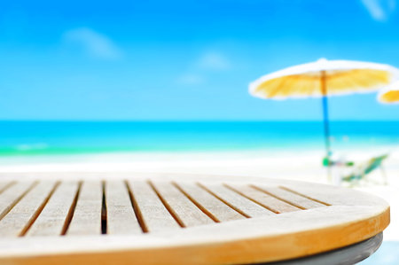 Round wood table top on blur beach background - can be used for display or  montage your products