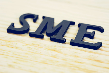 SME (or Small and Medium Enterprises) sign on wood backgroundの写真素材