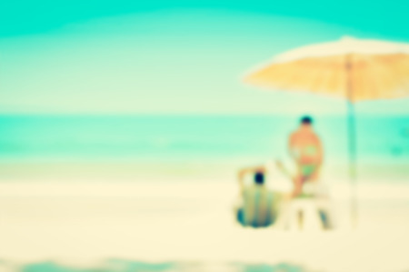 Blurred beach background with parasol and some people - holiday and vocation background conceptの写真素材