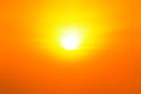 Orange sky with bright sun shining in twilightの写真素材