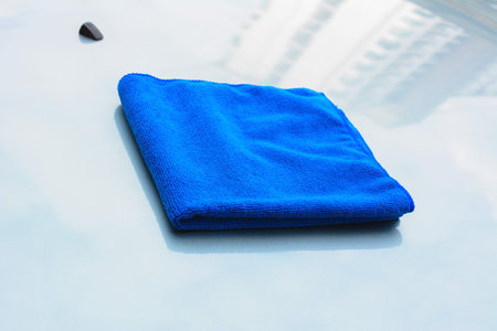 Blue microfiber cleaning cloth on car bonnetの写真素材