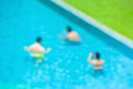Blurred image of a few people in swimming pool