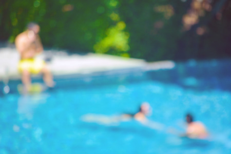 Blurred image of people relaxing at swimming pool - recreational background conceptの写真素材
