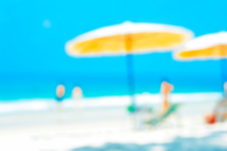 Blurred beach background with beach umbrellas and some people - summer holiday background conceptの写真素材