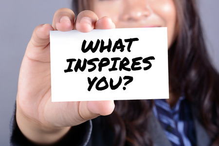WHAT INSPIRES YOU? message on the card shown by businesswomanの写真素材