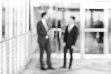 Blurred  image of businessmen greeting and having conversation at the corridor, business background concept in monochromeの写真素材