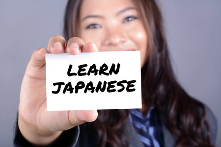 LEARN JAPANESE, message on the card held by young woman