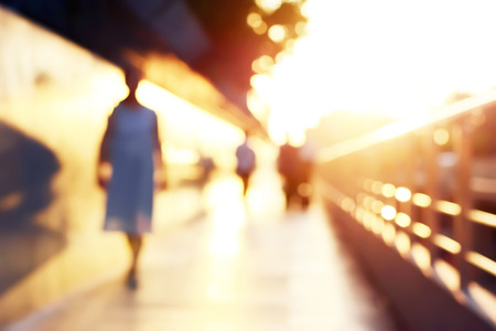 Blur silhouette of people walking on walkway in twilightの写真素材