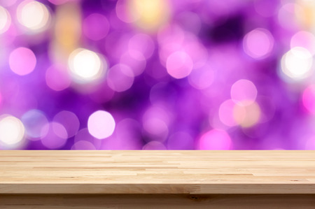 Wood table top on colorful purple bokeh abstract background - can be used for montage or display your productsの写真素材