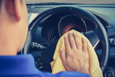 A man cleaning car steering wheel with microfiber cloth, vintage tone imageの写真素材