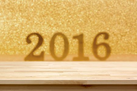 Wood table top on blur golden glittering 2016 backgroundの写真素材