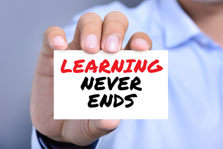 LEARNING NEVER ENDS message on the card shown by a man