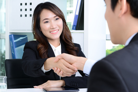 Asian businesswoman making handshake with a businessman in the officeの写真素材
