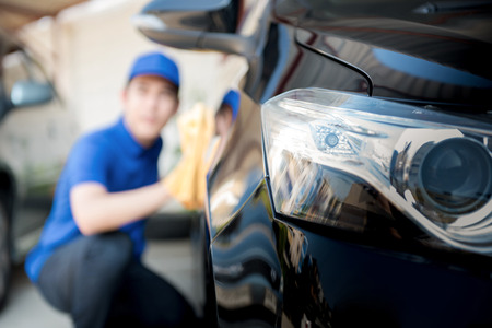 Car (auto) cleaning staff cleaning car - selective focusの写真素材