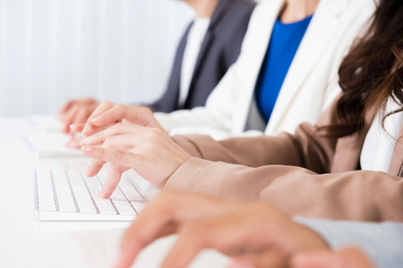 Business people hands typing on computer keyboardsの写真素材