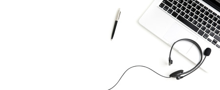 Microphone headset with notebook computer and pen on white table - panoramic banner background with copy space, top viewの写真素材