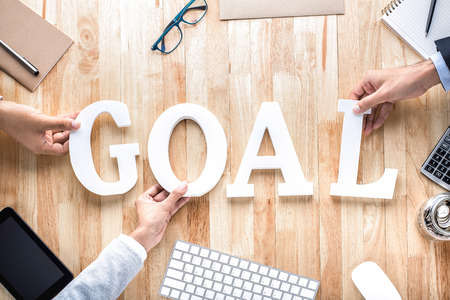 Business people hands arranging letters GOAL on working table -goal setting conceptの写真素材