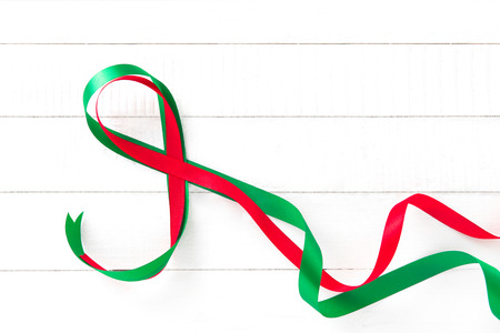 Red and green ribbon on white wood backgroundの写真素材