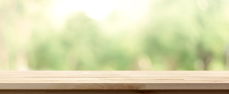 Wood table top on blur green background of trees in the park, panoramic banner - can be used for display or montage your productsの写真素材